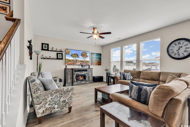 living room featuring ceiling fan and light hardwood / wood-style floors