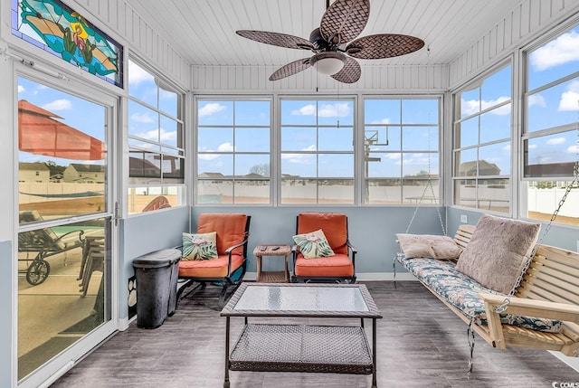 sunroom with ceiling fan, wood ceiling, and a wealth of natural light