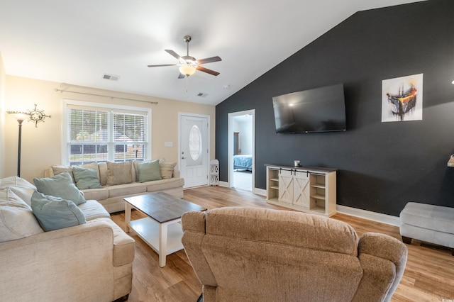 living room featuring ceiling fan, lofted ceiling, and light wood-type flooring