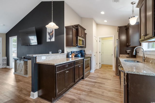 kitchen featuring a healthy amount of sunlight, light hardwood / wood-style flooring, stainless steel appliances, and decorative light fixtures