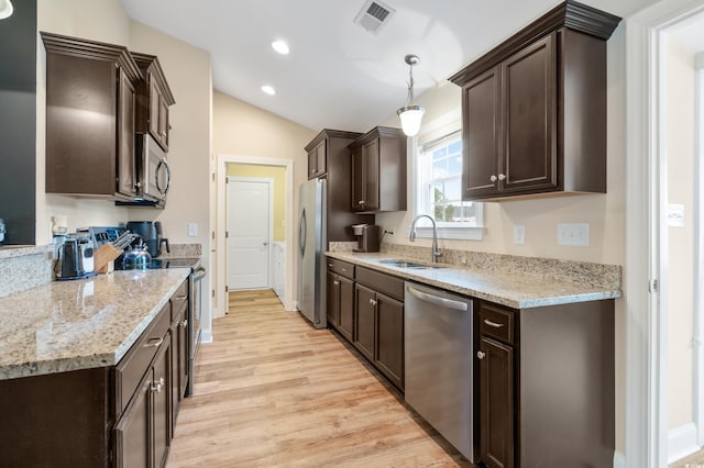 kitchen featuring stainless steel appliances, sink, light hardwood / wood-style flooring, hanging light fixtures, and lofted ceiling