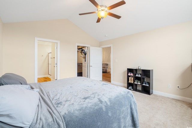 bedroom with light carpet, a walk in closet, ceiling fan, a closet, and lofted ceiling