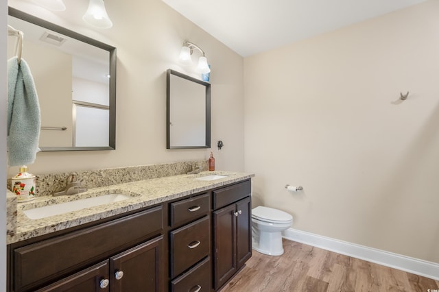 bathroom with hardwood / wood-style floors, vanity, and toilet