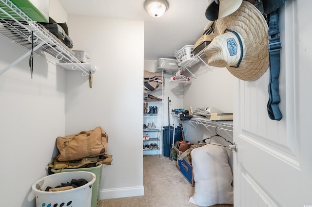 walk in closet featuring light colored carpet