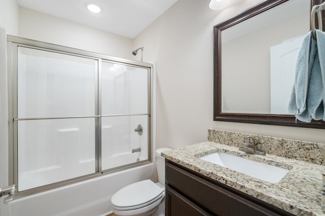 full bathroom with shower / bath combination with glass door, vanity, and toilet