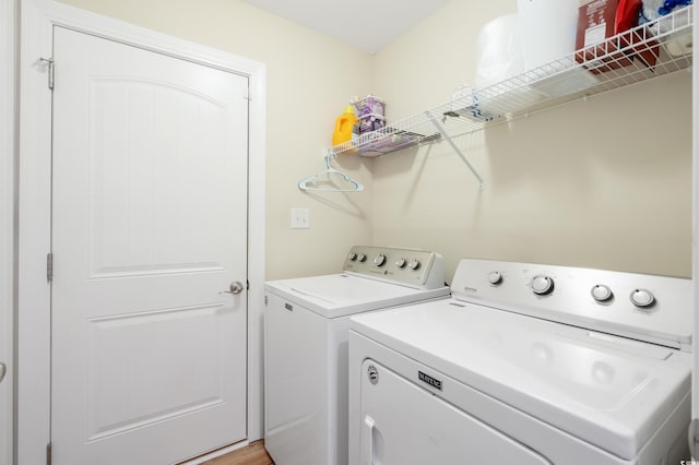 laundry room with washer and clothes dryer and hardwood / wood-style flooring