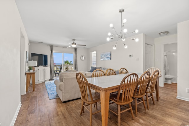 dining room featuring ceiling fan with notable chandelier and light wood-type flooring