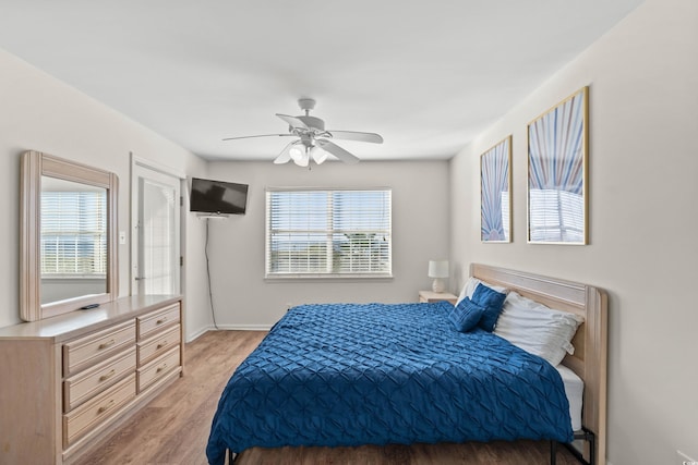 bedroom featuring light wood-type flooring, multiple windows, and ceiling fan