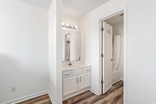 bathroom with hardwood / wood-style flooring, shower / bath combo, and vanity