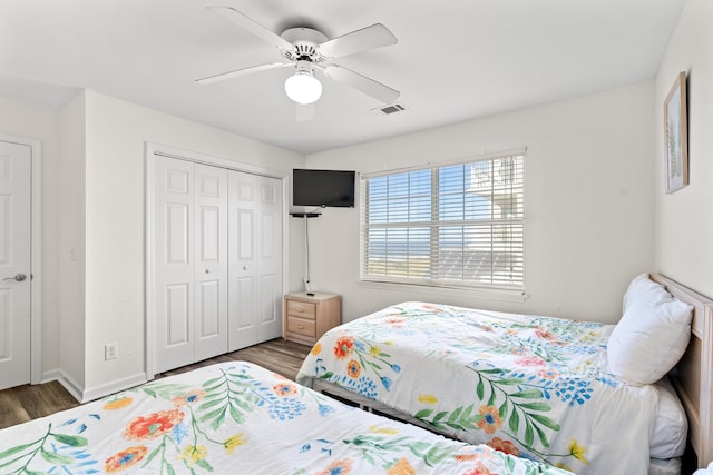 bedroom with dark hardwood / wood-style flooring, ceiling fan, and a closet