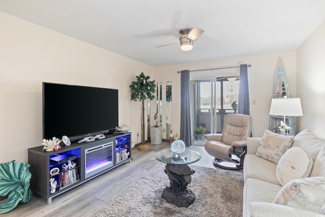 living room featuring ceiling fan and light hardwood / wood-style floors