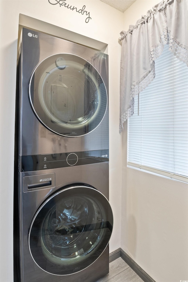 washroom with stacked washing maching and dryer