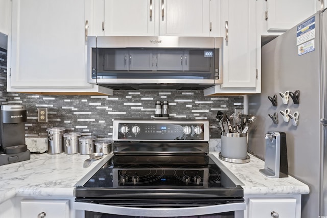 kitchen with backsplash, stainless steel appliances, and white cabinetry