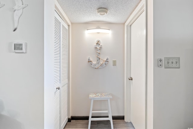 hallway featuring a textured ceiling and hardwood / wood-style flooring