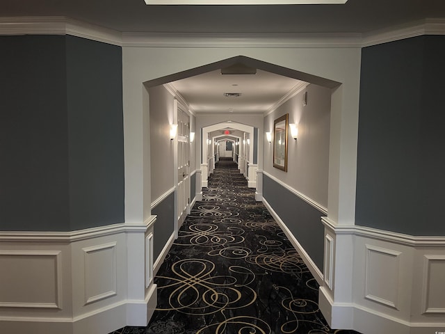 corridor featuring crown molding and dark colored carpet