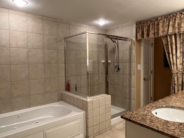 bathroom featuring tile patterned flooring, vanity, and shower with separate bathtub