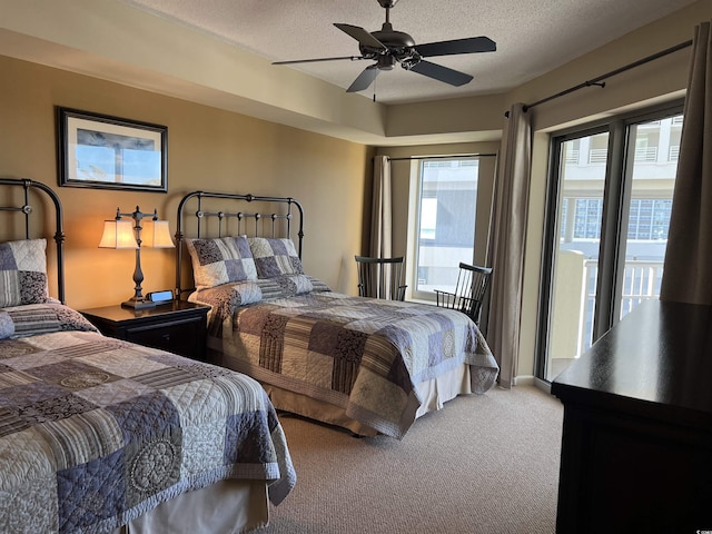 carpeted bedroom with access to exterior, a textured ceiling, and ceiling fan