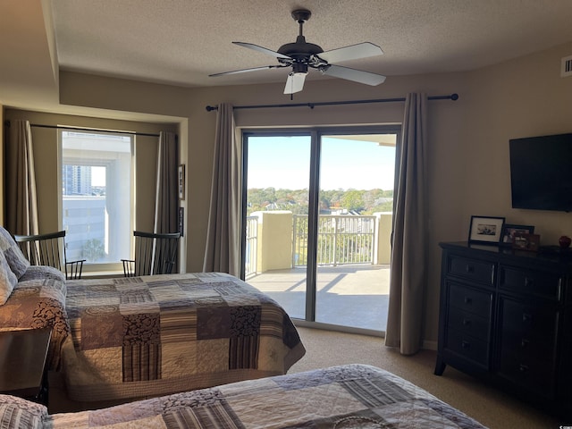 carpeted bedroom featuring access to outside, multiple windows, ceiling fan, and a textured ceiling