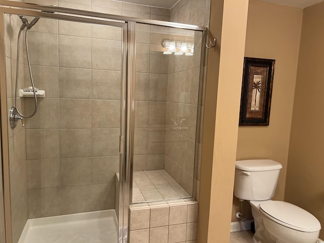 bathroom with a shower with shower door and toilet