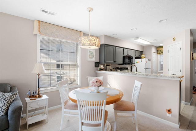 carpeted dining area featuring sink