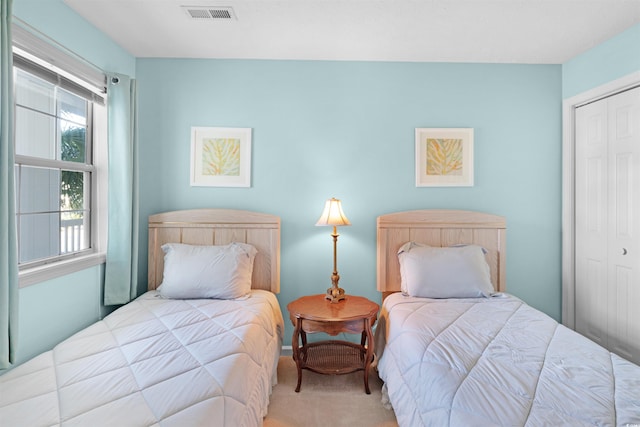 bedroom featuring light carpet and a closet