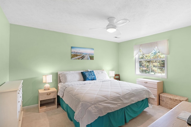 carpeted bedroom with a textured ceiling and ceiling fan