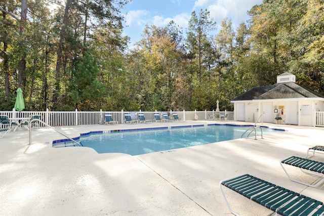 view of swimming pool featuring a patio area and an outdoor structure