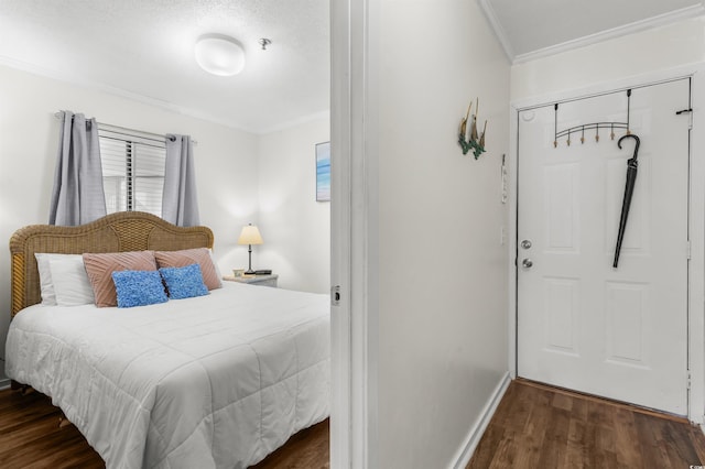 bedroom with dark hardwood / wood-style floors, crown molding, and a closet