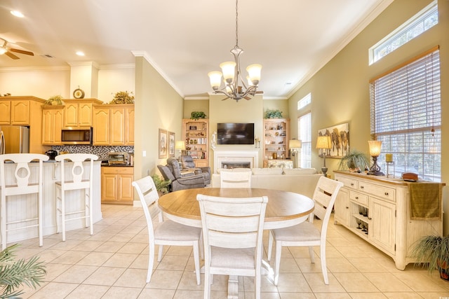 dining area with ceiling fan with notable chandelier, ornamental molding, and light tile patterned floors