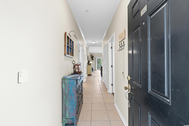 hall featuring ornamental molding and light tile patterned floors