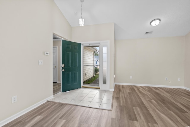 foyer entrance with light wood-type flooring and lofted ceiling