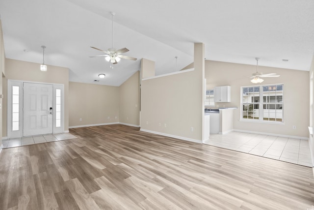 unfurnished living room featuring ceiling fan, vaulted ceiling, and light wood-type flooring