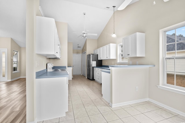 kitchen with stainless steel refrigerator, white cabinetry, ceiling fan, and range