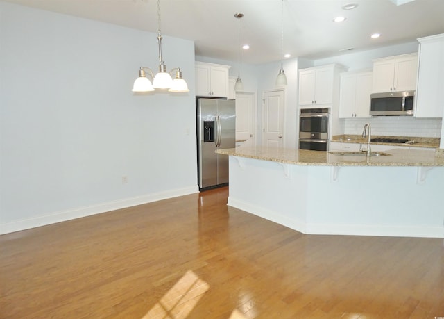 64 Summerlight Dr, Murrells Inlet, SC 29576 - kitchen with a sink, stainless steel appliances, tasteful backsplash, a breakfast bar, and wood finished floors