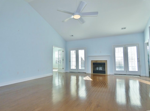 unfurnished living room with hardwood / wood-style floors, french doors, high vaulted ceiling, and ceiling fan