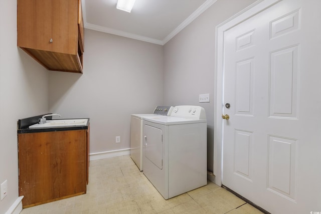 laundry area with cabinets, washer and dryer, crown molding, and sink