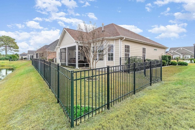 view of home's exterior with a yard and a sunroom