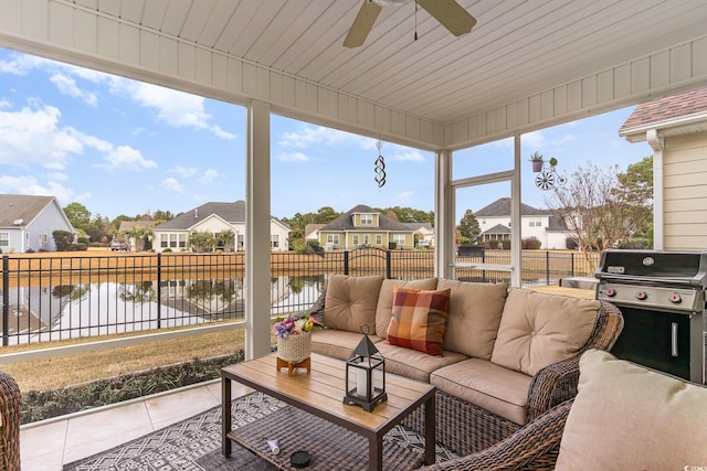 sunroom / solarium with a water view and ceiling fan