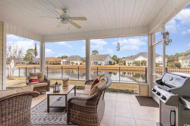 sunroom / solarium with ceiling fan, a water view, and wood ceiling