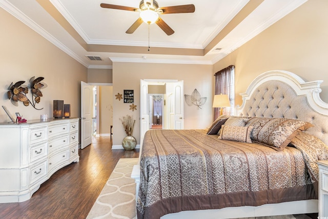 bedroom featuring a tray ceiling, ceiling fan, dark hardwood / wood-style flooring, and crown molding