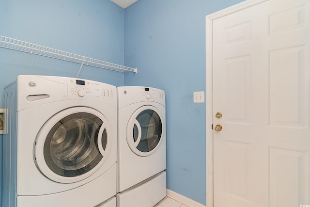 washroom with washer and clothes dryer and light tile patterned floors