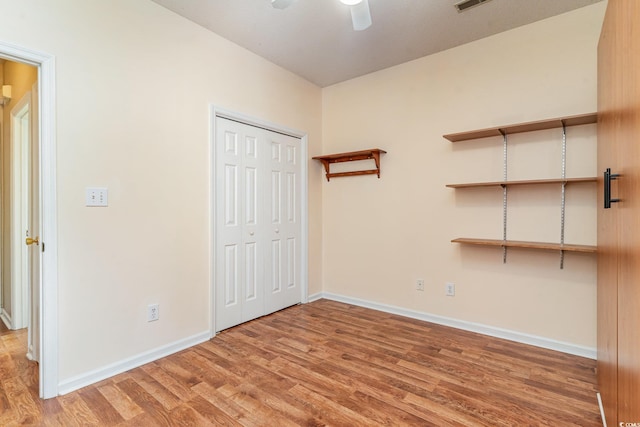 unfurnished bedroom with hardwood / wood-style flooring, a closet, and ceiling fan