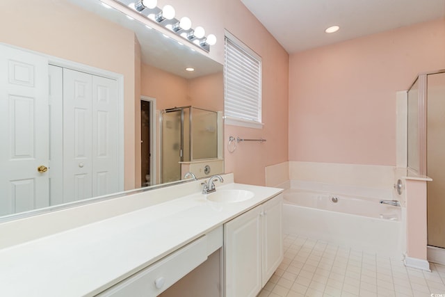 bathroom with plus walk in shower, vanity, and tile patterned flooring