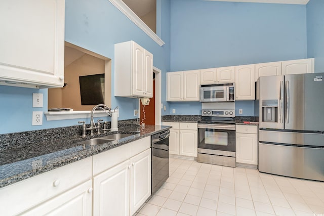 kitchen featuring white cabinets, sink, stainless steel appliances, and high vaulted ceiling