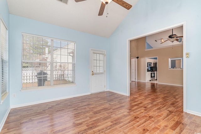 empty room with light hardwood / wood-style flooring and high vaulted ceiling