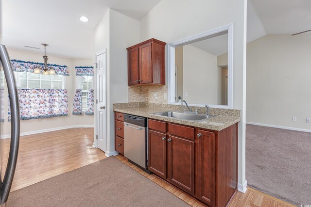 kitchen with stainless steel dishwasher, lofted ceiling, pendant lighting, refrigerator, and sink