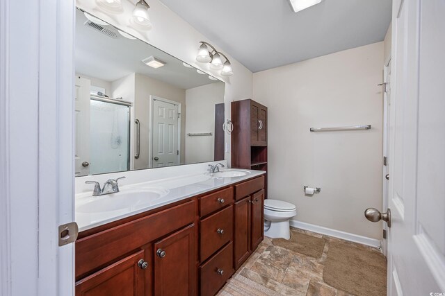 bathroom featuring toilet, a shower with door, and vanity