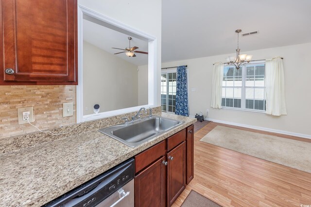 kitchen with pendant lighting, dishwasher, sink, backsplash, and light hardwood / wood-style flooring