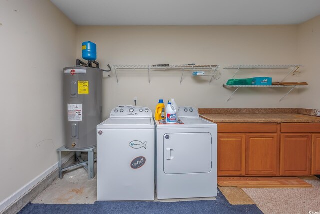 washroom with electric water heater, separate washer and dryer, and cabinets