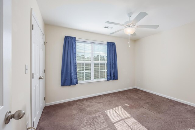 carpeted spare room featuring ceiling fan